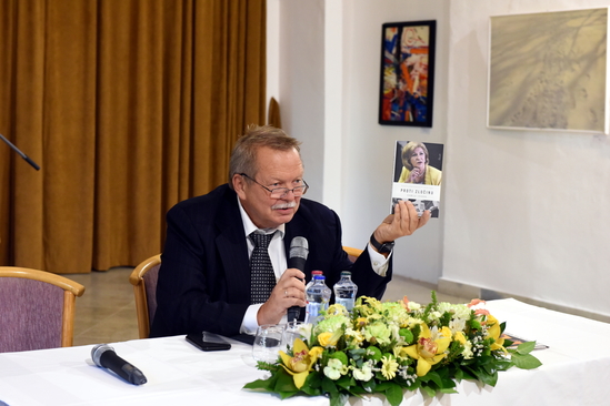 Predsedajúci P. Kasalovský ukazuje prítomným knihu Ľ. Lackovej Proti zločinu, ktorá je o službe spravodlivosti JUDr. E. Mišíkovej