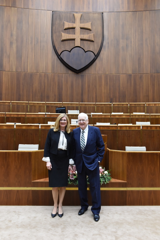 Vzácny hosť z USA K. M. Quinn spolu s G. Matečnou pred štátnym znakom v rokovacej sále NR SR.